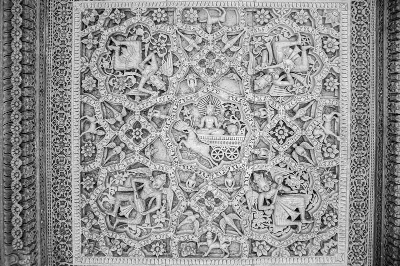 A ceiling panel inside a pavilion depicting a figure of Sun God together with celestial beings playing music, placed amidst floral designs on Rajsamand embankment